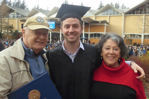 Anthony Carter shows his diploma from Western Washington University on Graduation Day. Standing with the graduate are his parents