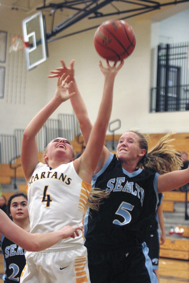 Sydney Severson of Bainbridge High reaches for an offensive rebound during the Spartan victory over Chief Sealth in the Metro League tournament earlier this week.