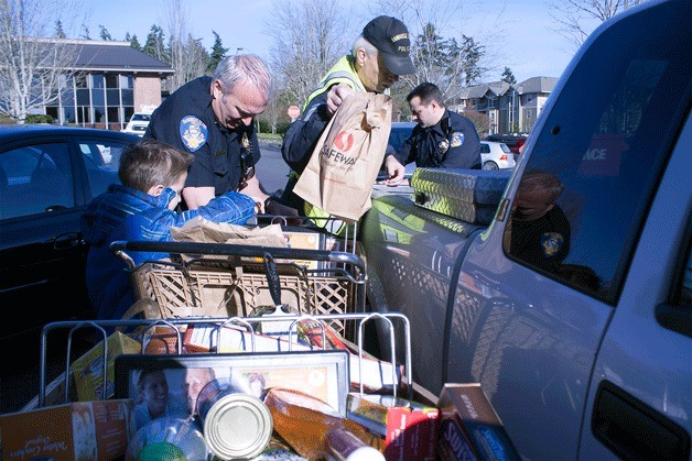 Bainbridge police officers load Stuff the Turkey donations for Helpline House outside the Safeway.