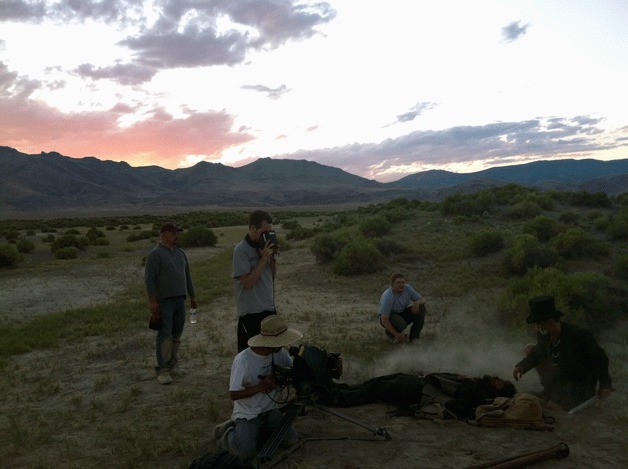 Scott Blake stands with his eyes in a viewfinder on the set of “The Surveyor.” With him are (from left) Darren Haffner