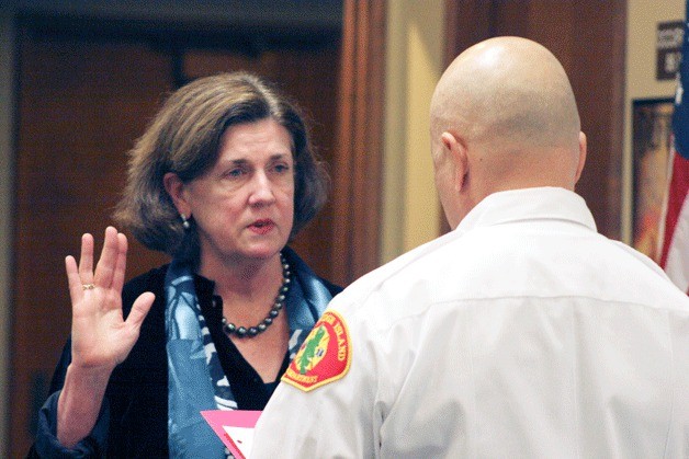 Eileen McSherry takes the oath of office as a Bainbridge Island fire commissioner at this week's board meeting.