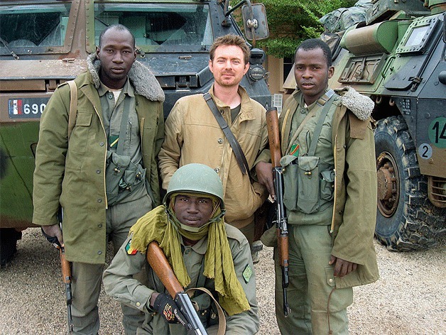 John Thorne stands for a photo with Malian soldiers at the Timbuktu Airfield in Mali in January 2013.