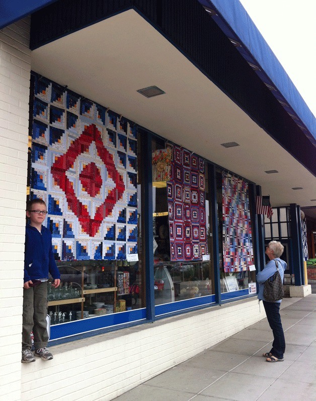 Passers-by check out one of the quilts hanging on Winslow Way during last year's Bainbridge Quilt Festival.