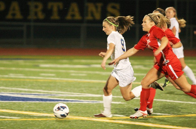 The Spartans' Natalie Vukic tries to get in front of Knight defender Ali Lundberg during first-half action Tuesday in the Metro League matchup. Vukic finished with one goal and had two assists in the Spartan win.