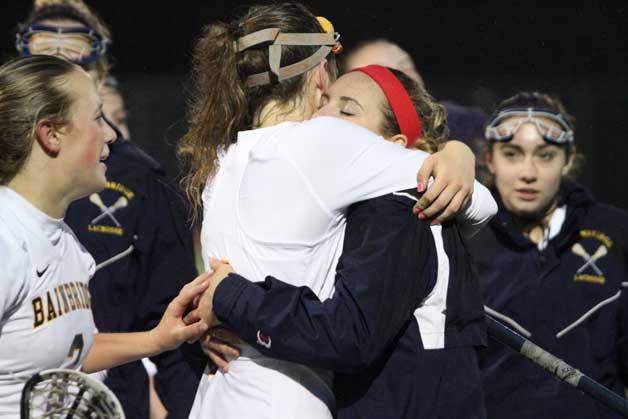 Members of the Bainbridge girls lacrosse team share hugs after beating Lakeside to advance to the state championship title game.