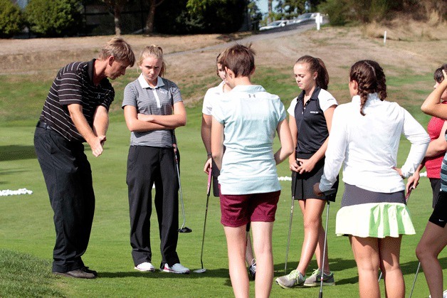 Bainbridge Coach Ian Havill demonstrates proper form to the Spartan girls varsity golf team.