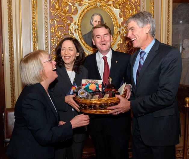 U.S. Senators Patty Murray and Maria Cantwell accept a basket filled with treats for the table from Colorado from that state's two members of the Senate