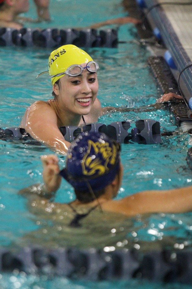 Bainbridge’s Caitlyn Munter congratutes Birdie Harvey of West Seattle after the BHS 200-yard medley team took first in the event at last week’s home meet.