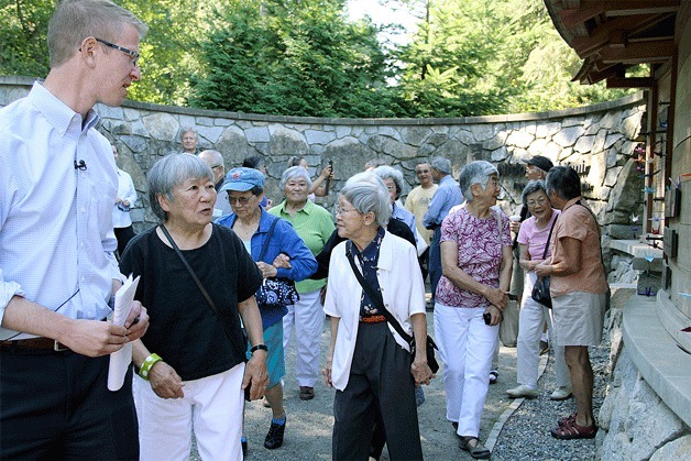 U.S. Rep. Derek Kilmer takes a tour of the Japanese American Exclusion Memorial with survivors of the World War II internment camps Monday. Many survivors shared stories and pointed out their names