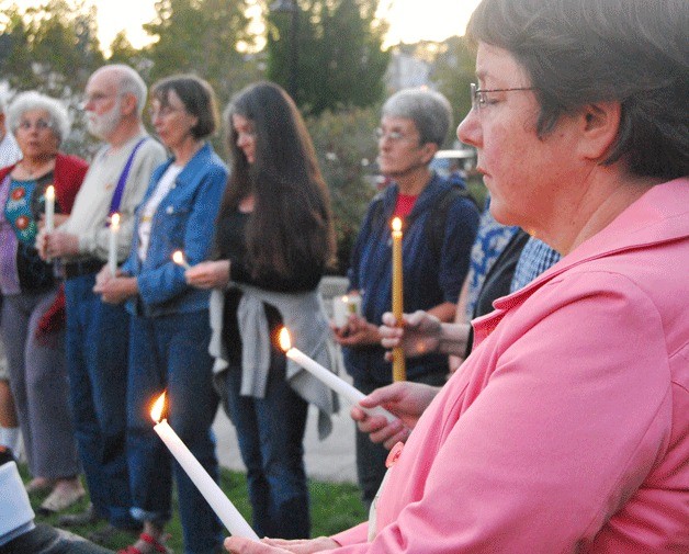 Jane Martin stands in silence in reflection for international peace at a candlelight vigil held on Monday