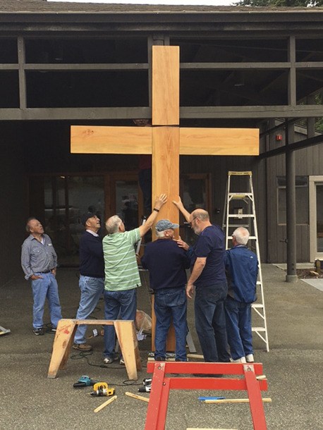 Members of the Rolling Bay Presbyterian Church mount their new cross