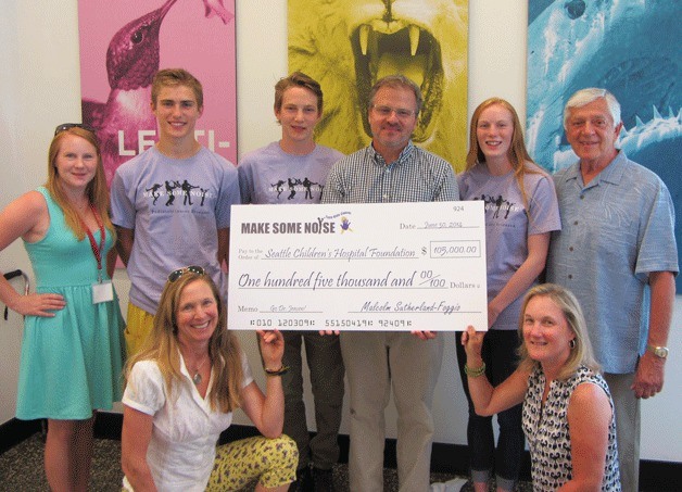 Representatives of the Northwest chapter of Make Some Noise: Cure Kids Cancer present a $105