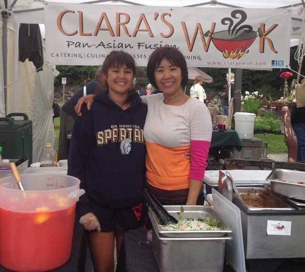 Gisella Gonzalez (left) and Clara Tan (right) prepare pan-Asian cuisine at Clara’s Wok at Saturday’s Farmers Market.