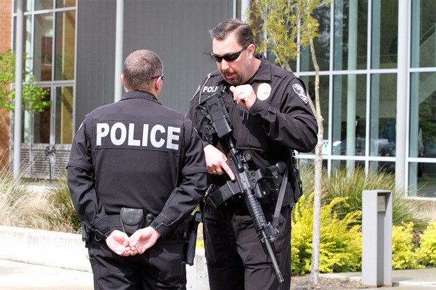 Officers from the Poulsbo Police Department stand near the front of Bainbridge High School after the school was locked down Wednesday after a report of a student carrying a gun into the school was received.