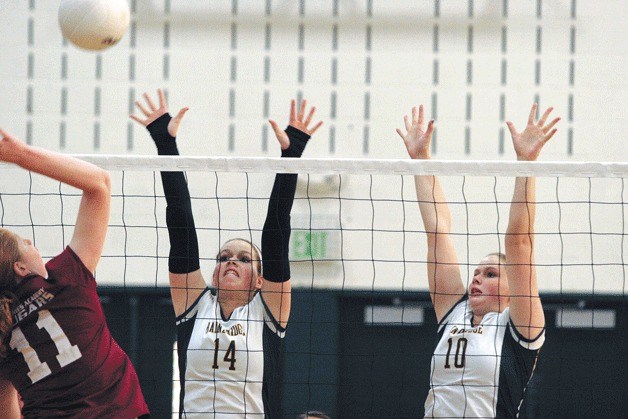 Maggie Haskin and Tess Haskin leap to block a shot by Courtney Pharr of Holy Names during Bainbridge’s big win against the top-ranked team earlier this week.