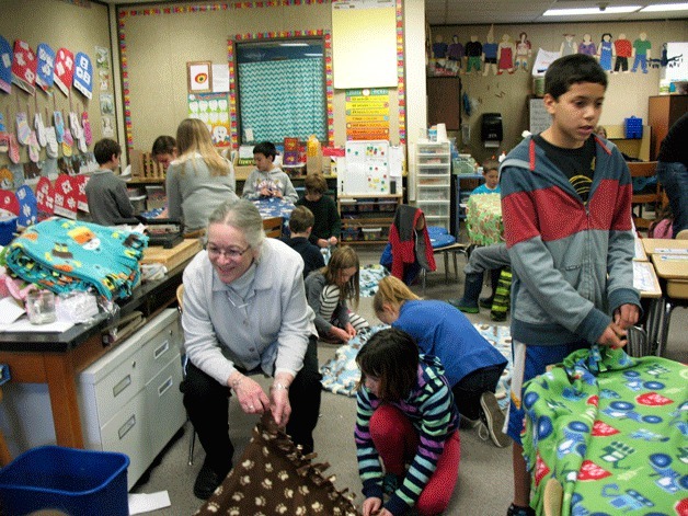 Teacher Julia Graves’ students at Opstad Elementary work with their buddies from Sonoji Sakai Intermediate School on blankets for kids in need as part of a cooperative project between the two classes.