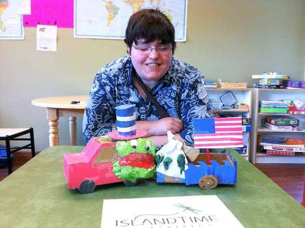 M’Rissa Curran of Island Time Activities shows off a finished model of the group’s July 4 parade float.