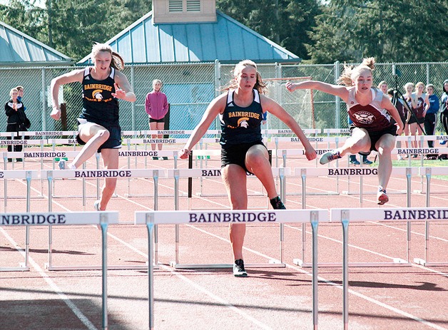 Elizabeth Messinger and Makaila Deen​ run the 100-meter hurdle event at last week’s track and field meet at Bainbridge High School.
