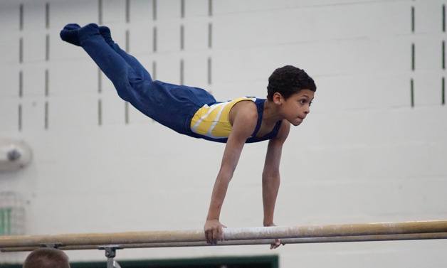 Jayden Wood-Johnson is the picture of concentration as he competes on parallel bars during the state gymnastics meet.
