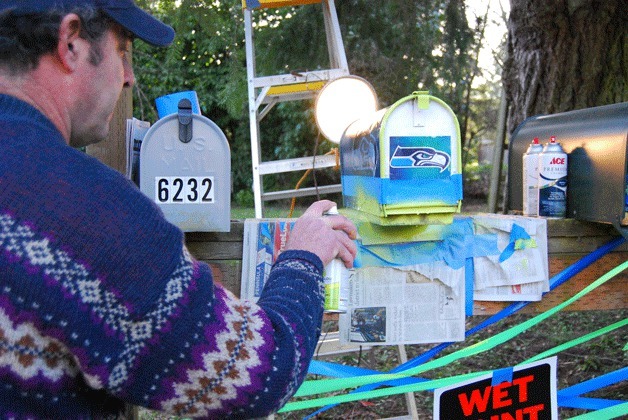Timothy Witten spray paints his neighbor’s mailbox Seahawks colors in honor of a longstanding Super Bowl bet between the two.