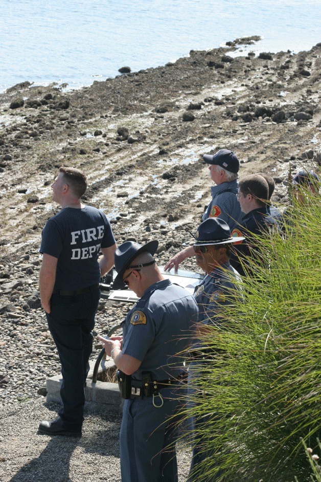 Personnel from the Bainbridge Island Fire Department and Washington State Patrol watch from a command center on South Beach as the search for a missing diver continues Tuesday.