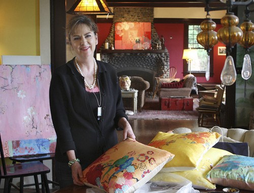 Kathe Fraga is surrounded by her artwork — on canvas