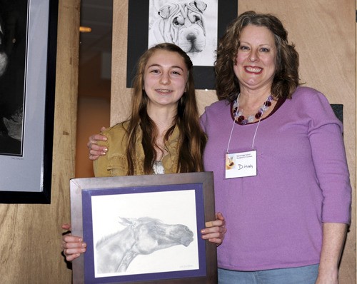 Katie Gustafson holds her drawing which won “Best of Show” in the Student Art Contest organized by Dinah Satterwhite