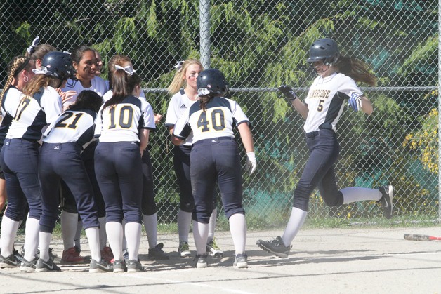 The Spartans gather at home plate to cheer on Megan Spray after she hit a homer against Blanchet.