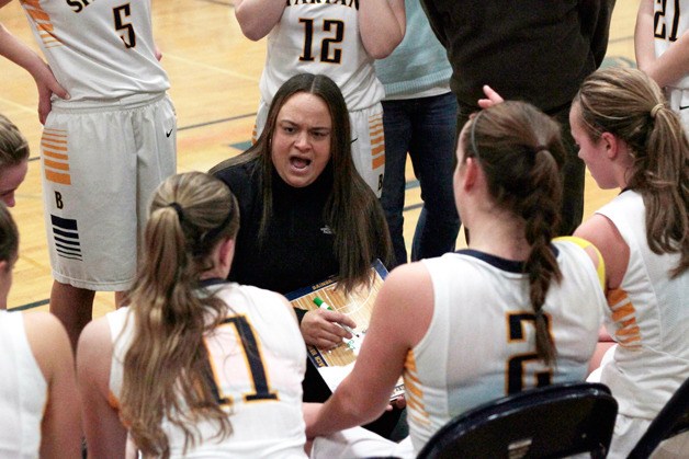 Spartan Head Coach Nicole Hebner talks with the girls varsity basketball team at halftime of Friday's game.
