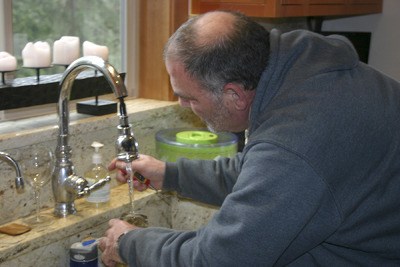 RePower Bainbridge Energy Advisor Rick Blumenthal checks water heating qualities during a Home Energy Check-up.