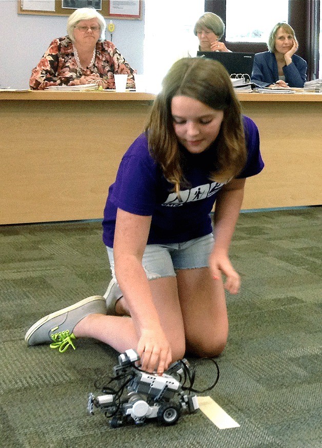 Bainbridge student Josie Hill demonstrates to the school board at its June 13 meeting how she can program a robot to follow a path on the floor. A grant from the Bainbridge Community Foundation will help fund an expansion of the robotics program currently in place in the middle grades to the  elementary schools.