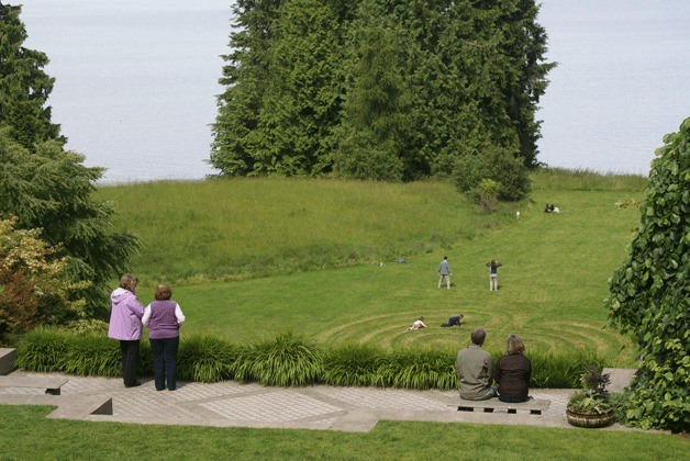 Visitors to the Bloedel Reserve admire the labyrinth feature that is situated among a peaceful setting and a stunning view over Puget Sound.