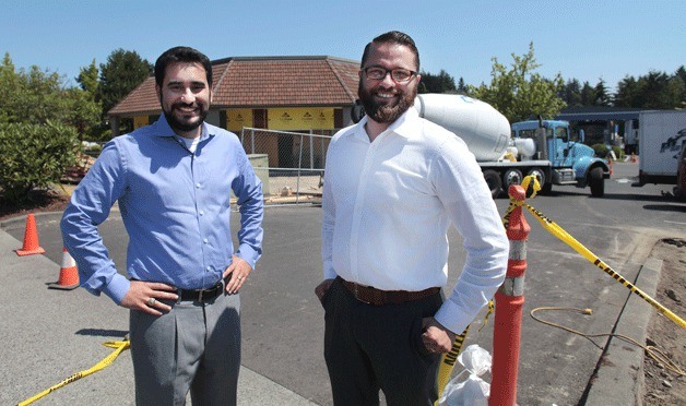 Starbucks district manager Dave Teves and manager of the new Bainbridge Island shop Rusten Harris stand in front of the company’s new Island Village Shopping Center location
