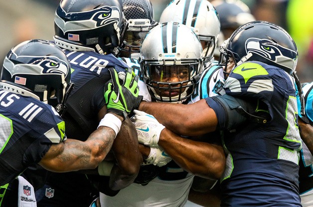 Seahawks' defense gang tackle Panthers' running back Jonathan Stewart Sunday afternoon at Century Link Field in Seattle