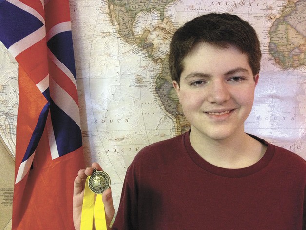 Evan Lisinski displays his medal for winning the 2013 National Geographic Bee recently at Woodward Middle School. He will now compete in the state contest at Pacific Lutheran University.