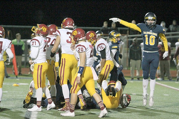 The Spartans’ Michael Greenwood jumps into the air to signal Bainbridge’s recovery of an O’Dea fumble during the first quarter of last week’s Metro League contest against the Fighting Irish.