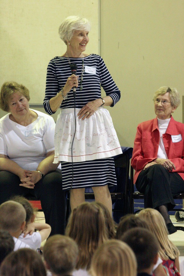 Former Wilkes Elementary teacher Sylvia Martine shows students an apron keepsake from her wedding shower that was signed by all of her students in 1960.