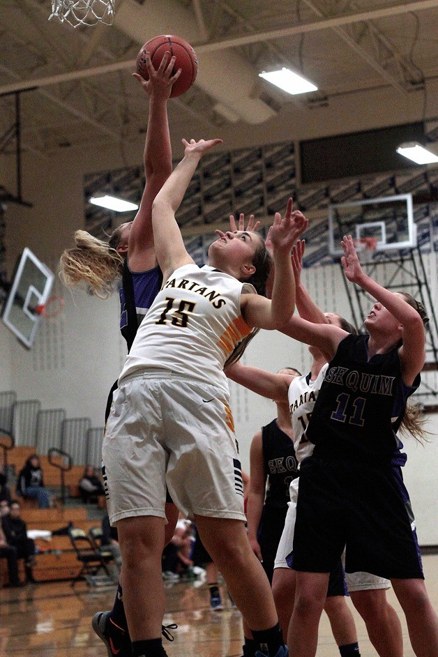 BHS junior post Paulina Bredy scrambles for a rebound during the varsity girls game against Sequim. The Spartans led early and maintained the advantage throughout the season’s debut game.
