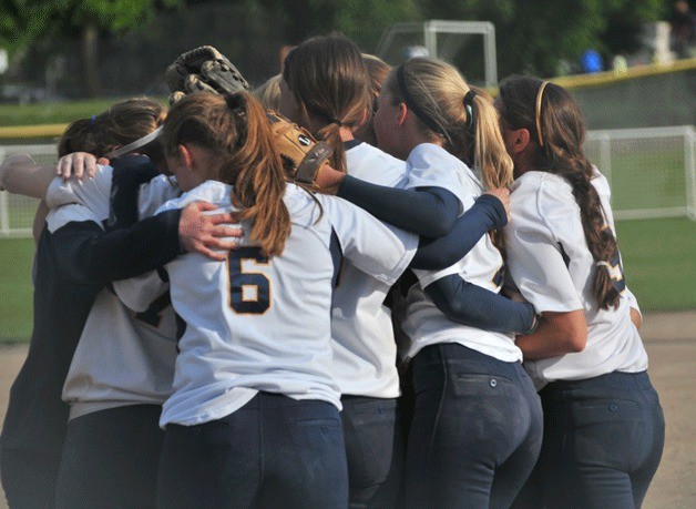 The Spartan fastpitch team gathers for a group hug after winning a trip to the state tournament.