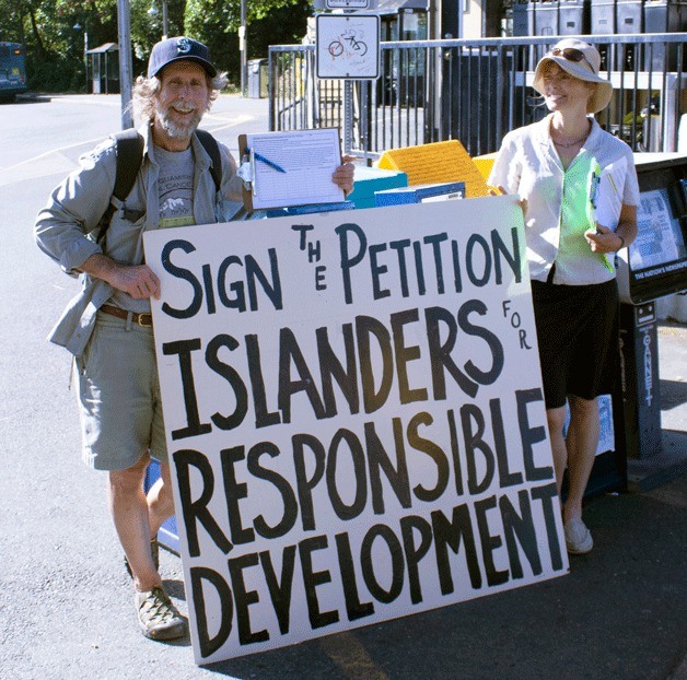 Organizer Ron Peltier collects signatures at the ferry terminal for a petition opposing the proposed retail center on the corner of Highway 305 and  High School Road with fellow protestor Tami Meader.