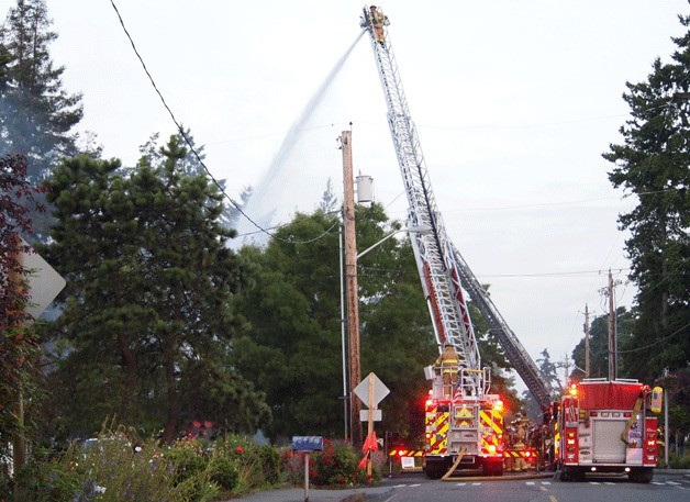 Bainbridge Island firefighters bombard the roof of The 122 from above with water from an aerial ladder truck to extinguish any remaining hot spots Monday morning.