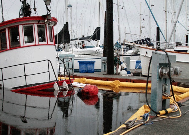 Oil-spill booms have been placed around the vessel &#039;Chickamauga&#039; to control pollution after the old tugboat sank Tuesday in Eagle Harbor.