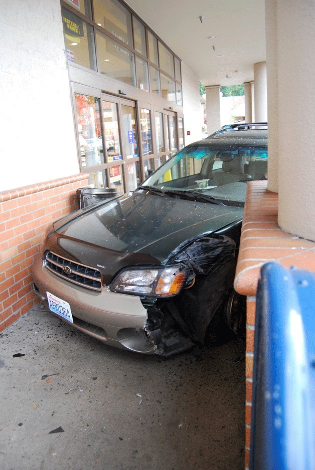 A Subaru Outback sits at the front of the Rite Aid entrance after a driver accidentally crashed into the Bainbridge store Monday.
