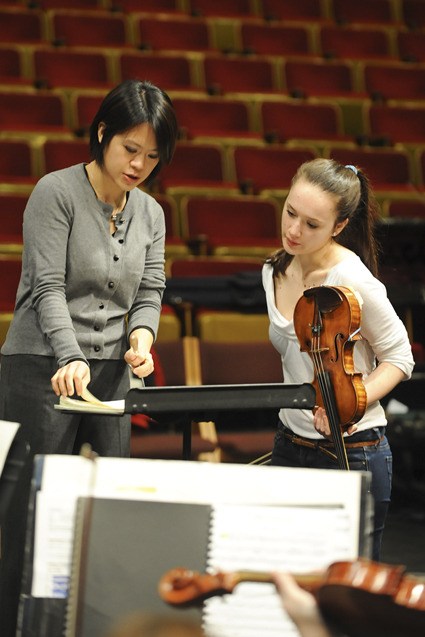 Bainbridge Symphony Orchestra Guest Conductor Julia Tai confers with Guest Violinist Sophia Stoyanovich before Wednesday’s rehearsal in preparation for this weekend's program 'Dusk Till Dawn