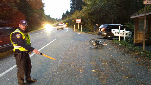 A Bainbridge Island police officer directs traffic after a bus-bike  accident on Highway 305 early last month.
