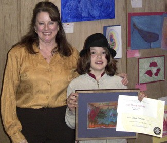 Student Art Contest organizer Dinah Satterwhite congratulates last year’s grade 3-4 first place winner Olivia Stocker.