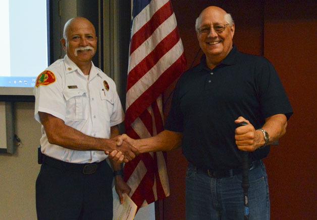 Bainbridge Island Fire Chief Hank Teran congratulates Bruce Alward on his appointment to the board of fire commissioners.