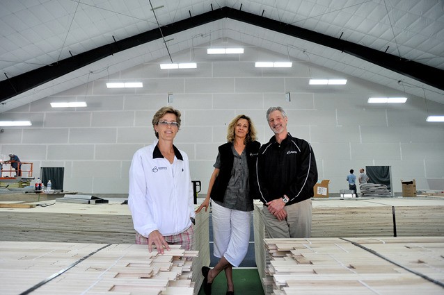 (L-R) Bainbridge Athletic Club owners Shelly Stockman and Kellan and Ted Eisenhardt in front of the newly constructed wall that separates a tennis court and new gymnasium space.