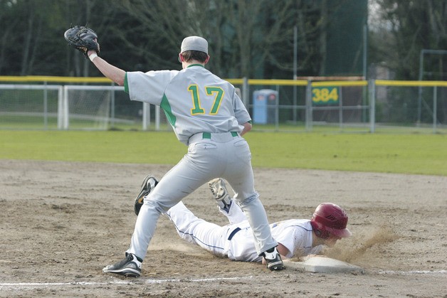 Spartan Nick Bierly slides back into first base while Conner Celli of Bishop Blanchet waits for the throw during the Spartans’ 13-3 win over the Braves.