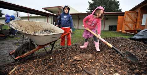 Odyssey Multiage Program students Grace Dunning and Zach Dashe move mulch into rows at the school’s garden plot. Students have grown more than 60 pounds of vegetables in the garden